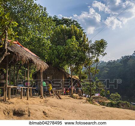 Stock Photography - People sitting in front of wooden huts, aboriginal Orang Asil tribe, indigenous culture, Taman Negara, Malaysia, Asia. Fotosearch