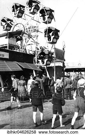 People walk over the fairground and look at the ferris wheel View Large Photo Image Stock Photo - People walk over the fairground and look at the ferris wheel. Fotosearch