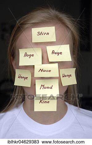 Stock Image - Post-it note with descriptions of body parts pasted over face. Fotosearch
