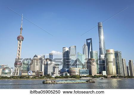 Stock Image - Pudong Area, Special Economic Zone, Municipality of Shanghai, on the eastern bank of Huang Po River, cargo ships, left the Oriental Pearl Tower from the middle the Shanghai Tower, Shanghai, China, Asia. Fotosearch