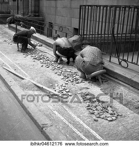 Stock Photograph - Road workers paving a road with natural stones, Freiburg ca. 1945 to 1955. Fotosearch