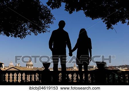 Stock Image - Silhouette couple holding hands overlooking the city of Rome, Italy, Europe. Fotosearch