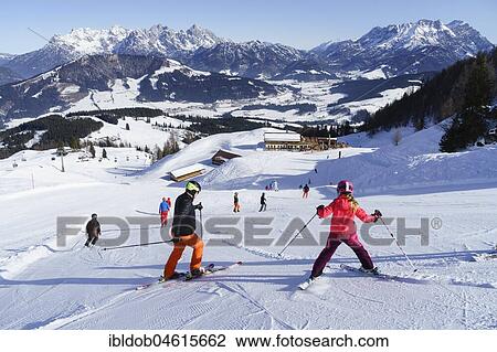 Stock Image - Skiers in front of alpine guesthouse Laerchfilz Hochalm, Buchensteinwand and Loferer as well as Leoganger Steinbergen, ski area Saalbach Hinterglemm Leogang Fieberbrunn, Fieberbrunn, Tyrol, Austria, Europe. Fotosearch