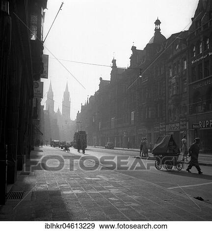 Street with cars, tram and a man with a cart, ca. 1945 to 1955, Freiburg, Germany, Europe View Large Photo Image Stock Photo - Street with cars, tram and a man with a cart, ca. 1945 to 1955, Freiburg, Germany, Europe. Fotosearch