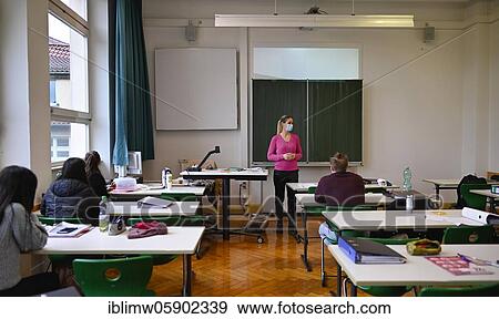 Stock Photo - Teacher with face mask in classroom, windows closed, corona crisis, Stuttgart, Baden-Württemberg, Germany, Europe. Fotosearch