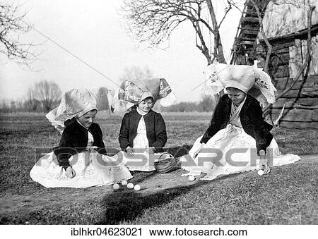 Stock Image - Three girls in traditional costume playing with eggs at Easter, Spreewald, ca. 1930, exact place unknown, Germany, Europe. Fotosearch