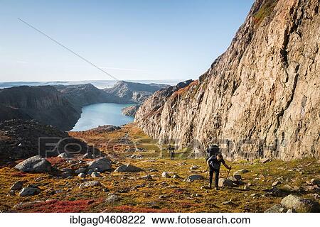 Stock Image - Trekking group runs along a rock face, back lake, West Greenland, Greenland, North America. Fotosearch