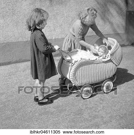 Stock Photography - Two children play with a doll in a pram, 1955, Freiburg, Germany, Europe. Fotosearch