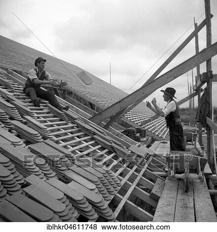 Two roofers throw themselves on a house tile to around 1950, surroundings of Freiburg, Germany, Europe View Large Photo Image Stock Photo - Two roofers throw themselves on a house tile to around 1950, surroundings of Freiburg, Germany, Europe. Fotosearch