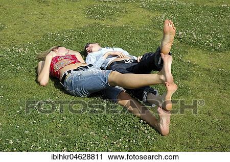 Two women lying in a meadow with feet stacked on top of each other, Berlin, Germany, Europe View Large Photo Image Stock Image - Two women lying in a meadow with feet stacked on top of each other, Berlin, Germany, Europe. Fotosearch