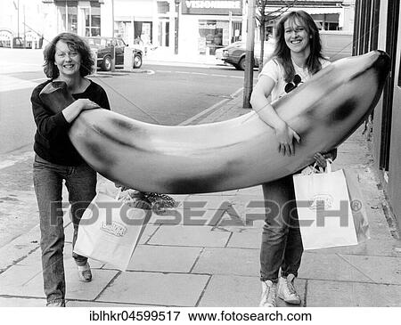 Stock Photo - Two women with big banana, England, Great Britain. Fotosearch
