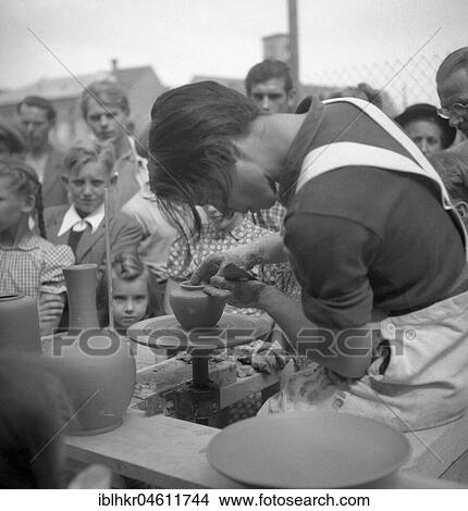 Picture - Töpferin produces a vessel in front of spectators, around 1950, Freiburg, Germany, Europe. Fotosearch