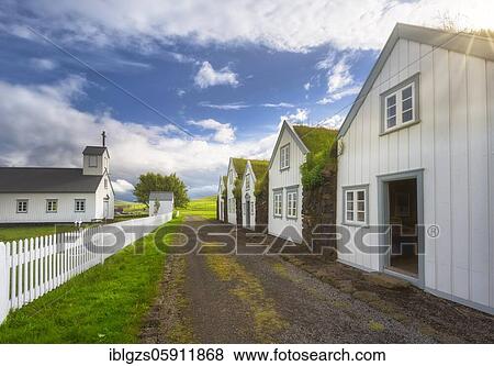 Stock Photo - White houses with grass roof and stone wall along a gravel road, church with white fence on peat yard, grass house settlement Grenjadarstadur, Grenjaðarstaður, Þingeyjarsveit, Norðurland eystra, Iceland, Europe. Fotosearch