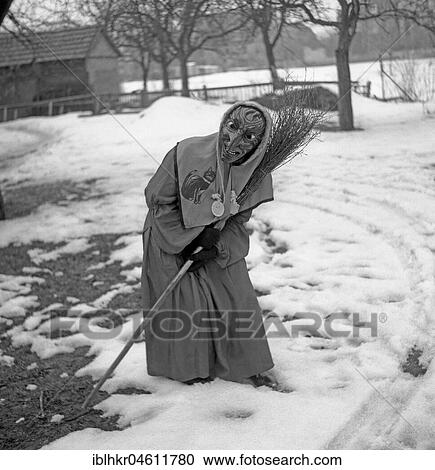 Witch with broom in hand stands in a curvilinear position in the snow, carnival, around 1950, near Freiburg, Germany, Europe View Large Photo Image Stock Image - Witch with broom in hand stands in a curvilinear position in the snow, carnival, around 1950, near Freiburg, Germany, Europe. Fotosearch