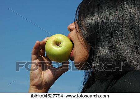 Picture - Woman eating an apple, Germany, Europe. Fotosearch