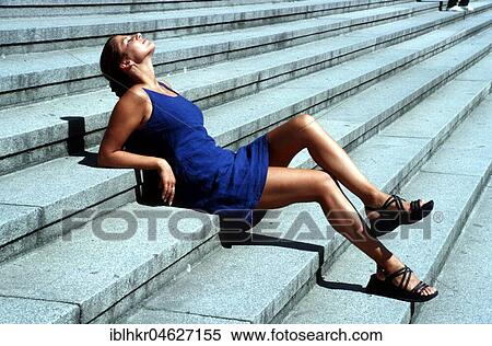Stock Photography - Woman in blue dress lying on stairs, Berlin, Germany, Europe. Fotosearch