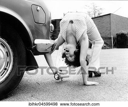 Woman looks under a car with flashlight, England, Great Britain View Large Photo Image Stock Photo - Woman looks under a car with flashlight, England, Great Britain. Fotosearch