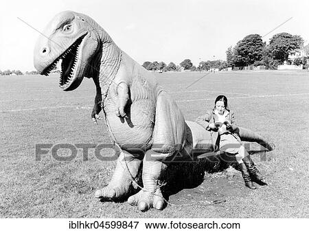 Stock Photo - Woman sitting on Dino, England, Great Britain. Fotosearch