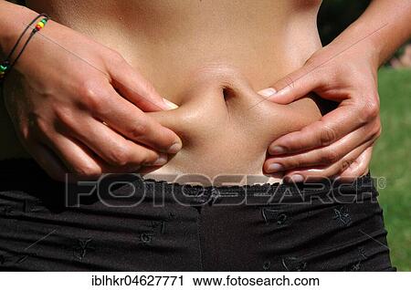 Stock Image - Woman testing abdominal fat, Germany, Europe. Fotosearch