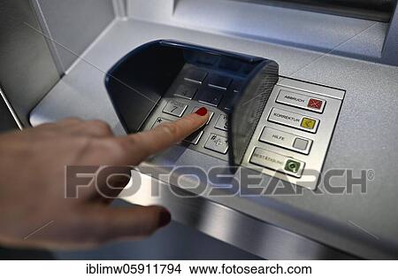 Woman typing in secret code at the cash machine of a savings bank, Waiblingen, Baden-Württemberg, Germany, Europe View Large Photo Image Picture - Woman typing in secret code at the cash machine of a savings bank, Waiblingen, Baden-Württemberg, Germany, Europe. Fotosearch