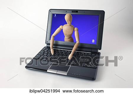 Picture - Wooden doll coming out of a laptop screen. Fotosearch