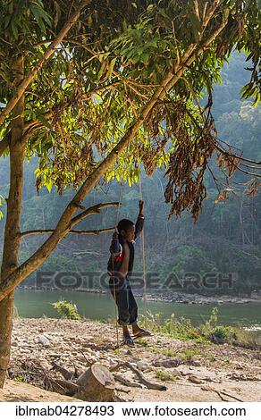 Stock Image - Young boy, aboriginal Orang Asil, rocks, Taman Negara, Malaysia, Asia. Fotosearch
