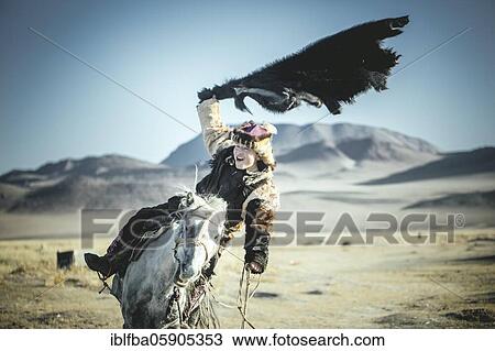 Young eagle hunter trains for the next Buzkaschi competition, equestrian game, Olgii, Mongolia, Asia View Large Photo Image Stock Image - Young eagle hunter trains for the next Buzkaschi competition, equestrian game, Olgii, Mongolia, Asia. Fotosearch