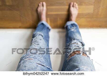 Stock Photo - Young girl in fashionable torn jeans with holes, Germany, Europe. Fotosearch