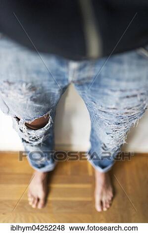 Stock Photo - Young girl in fashionable torn jeans with holes, Germany, Europe. Fotosearch