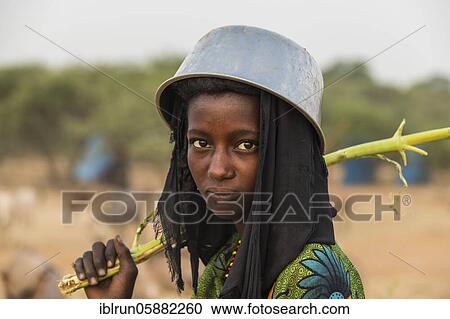 Young girl with a a water pot on her head, Gerewol festival, courtship ritual competition among the Woodaabe Fula people, Niger, Africa View Large Photo Image Stock Image - Young girl with a a water pot on her head, Gerewol festival, courtship ritual competition among the Woodaabe Fula people, Niger, Africa. Fotosearch