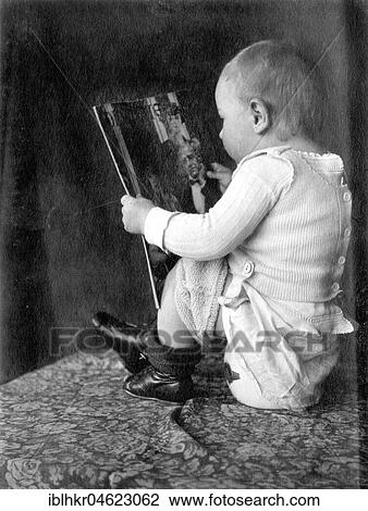 Stock Image - Baby reads magazine and sits on the pot ca. 1930, exact place unknown, Germany, Europe. Fotosearch