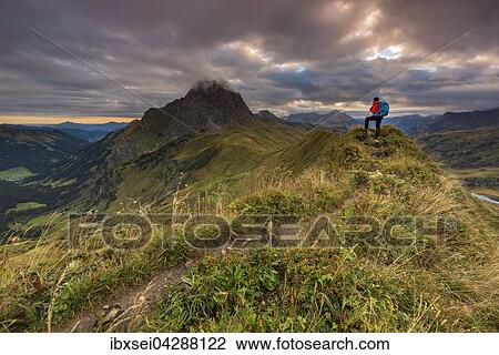 Bergsteiger blickt auf Gipfel des Widderstein, Allgauer Alpen, Wolkenstimmung am Morgen, Warth, Vorarlberg, Osterreich, Europa View Large Photo Image Stock Image - Bergsteiger blickt auf Gipfel des Widderstein, Allgauer Alpen, Wolkenstimmung am Morgen, Warth, Vorarlberg, Osterreich, Europa. Fotosearch