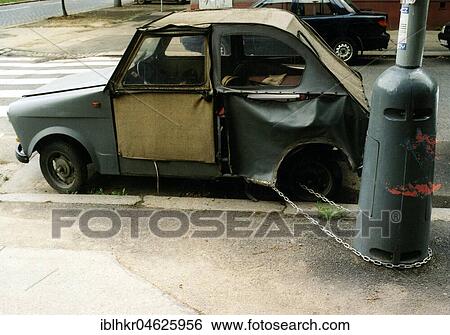 Stock Photograph - Broken car chained to a lamppost ca. 1970s, exact place unknown, Czech Republic, Europe. Fotosearch