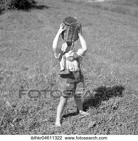 Child stands barefoot in a meadow and drinks water from a wooden-coated vessel, ca. 1955, near Freiburg, Germany, Europe View Large Photo Image Stock Image - Child stands barefoot in a meadow and drinks water from a wooden-coated vessel, ca. 1955, near Freiburg, Germany, Europe. Fotosearch
