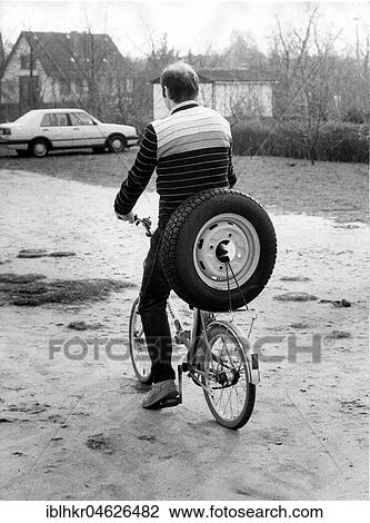 Stock Image - Cyclist transports car tire, approx. 1980s, East Berlin, GDR, Germany, Europe. Fotosearch