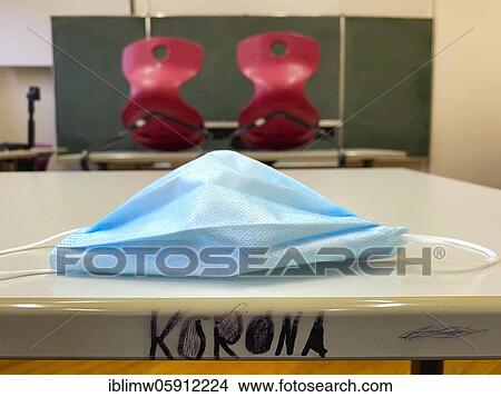 Picture - Empty classroom, seated, face mask and lettering KORONA on table, single tables without distance rule, Corona crisis, Germany, Europe. Fotosearch