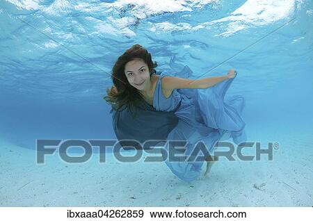 Stock Photo - Frau in einem Kleid schwimmt unter Wasser im Meer. Fotosearch