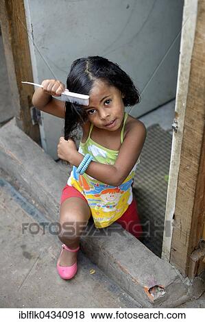 Girl brushing her hair, slum Favela 21 de Abril, São Paulo, Brazil, South America View Large Photo Image Stock Photo - Girl brushing her hair, slum Favela 21 de Abril, São Paulo, Brazil, South America. Fotosearch
