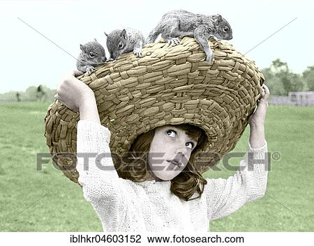 Stock Image - Girl with chipmunks sitting on her straw hat, England, Great Britain. Fotosearch