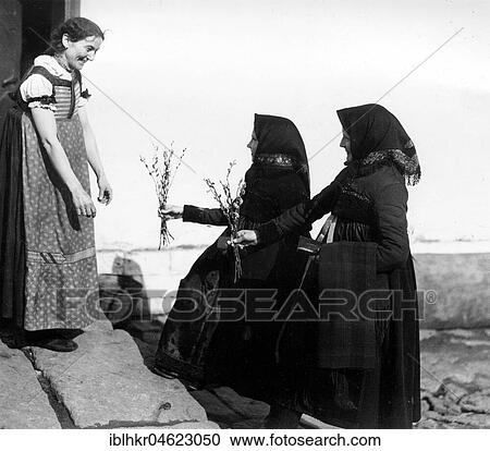 Stock Image - Landlady receives bouquet of flower girls ca. 1930, exact place unknown, Germany, Europe. Fotosearch