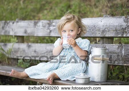 Madchen trinkt Milch auf einer Bank vor der Alm, Deutschland, Europa View Large Photo Image Stock Image - Madchen trinkt Milch auf einer Bank vor der Alm, Deutschland, Europa. Fotosearch