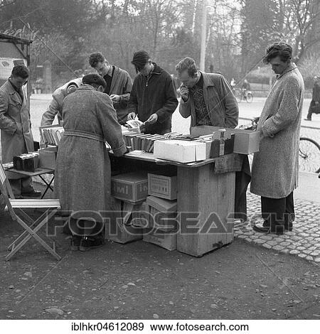 Stock Photo - Men browse the books at a market stall, Freiburger Münstermarkt, approx. 1945 to 1955, Freiburg, Germany, Europe. Fotosearch