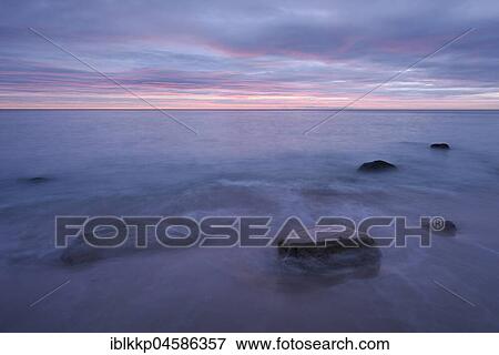 Stock Photo - Morning atmosphere at the sea, stones in the surf at the Baltic Sea coast near Sassnitz, Rügen, Mecklenburg-Western Pomerania, Germany, Europe. Fotosearch