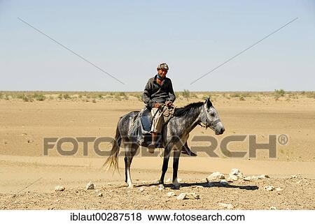 Nomads young rider on his horse in the sandy desert Kyzyl Kum Uzbekistan View Large Photo Image Stock Photo - Nomads young rider on his horse in the sandy desert Kyzyl Kum Uzbekistan. Fotosearch