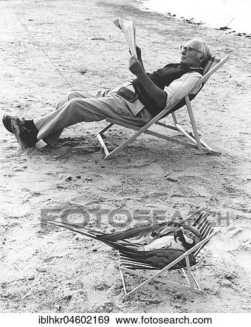 Stock Photo - Parrot and man in deck chair, England, Great Britain. Fotosearch