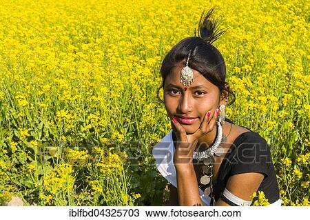 Portrait of a young local woman belonging to the Tharu tribe, sitting in a yellow mustard field, Sauraha, Chitwan, Nepal, Asia View Large Photo Image Stock Image - Portrait of a young local woman belonging to the Tharu tribe, sitting in a yellow mustard field, Sauraha, Chitwan, Nepal, Asia. Fotosearch