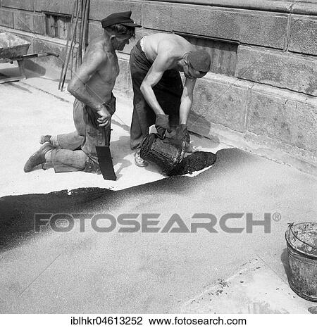 Stock Image - Road workers tar a road, ca. 1945 to 1955, Freiburg, Germany, Europe. Fotosearch