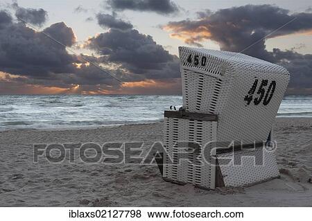 Roofed wicker beach chair on the beach just after sunset with dramatic clouds, Hoernum, Sylt, North Frisia, Schleswig-Holstein, Germany, Europe View Large Photo Image Stock Photo - Roofed wicker beach chair on the beach just after sunset with dramatic clouds, Hoernum, Sylt, North Frisia, Schleswig-Holstein, Germany, Europe. Fotosearch