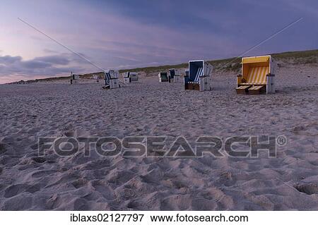 Stock Photo - Roofed wicker beach chairs on the beach just after sunset, Hoernum, Sylt, North Frisia, Schleswig-Holstein, Germany, Europe. Fotosearch