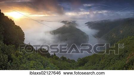 Stock Photograph - Saar Loop at sunrise with a light mist over the course of the river, Saar, Orscholz, Saarland, Germany, Europe. Fotosearch